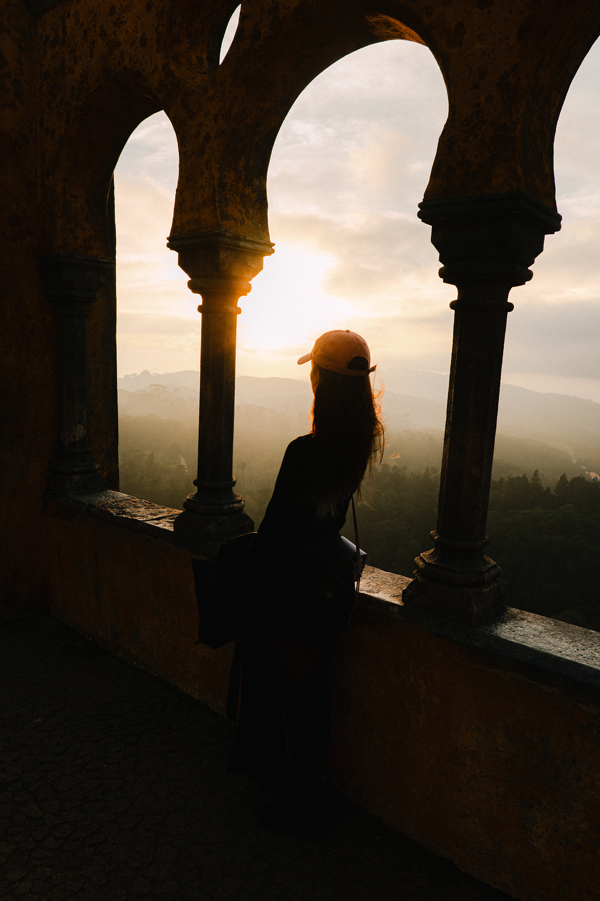 Silhouette through castle arches at sunset
