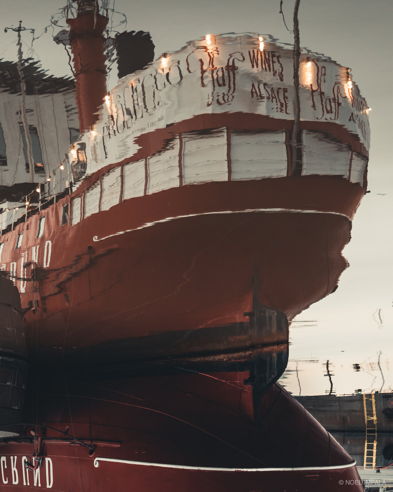 Red wine ship reflected in water