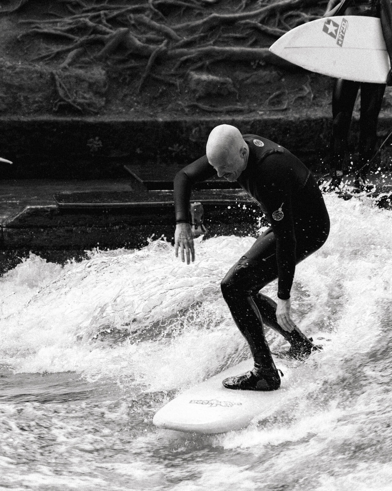 Surfer riding Eisbach wave black and white