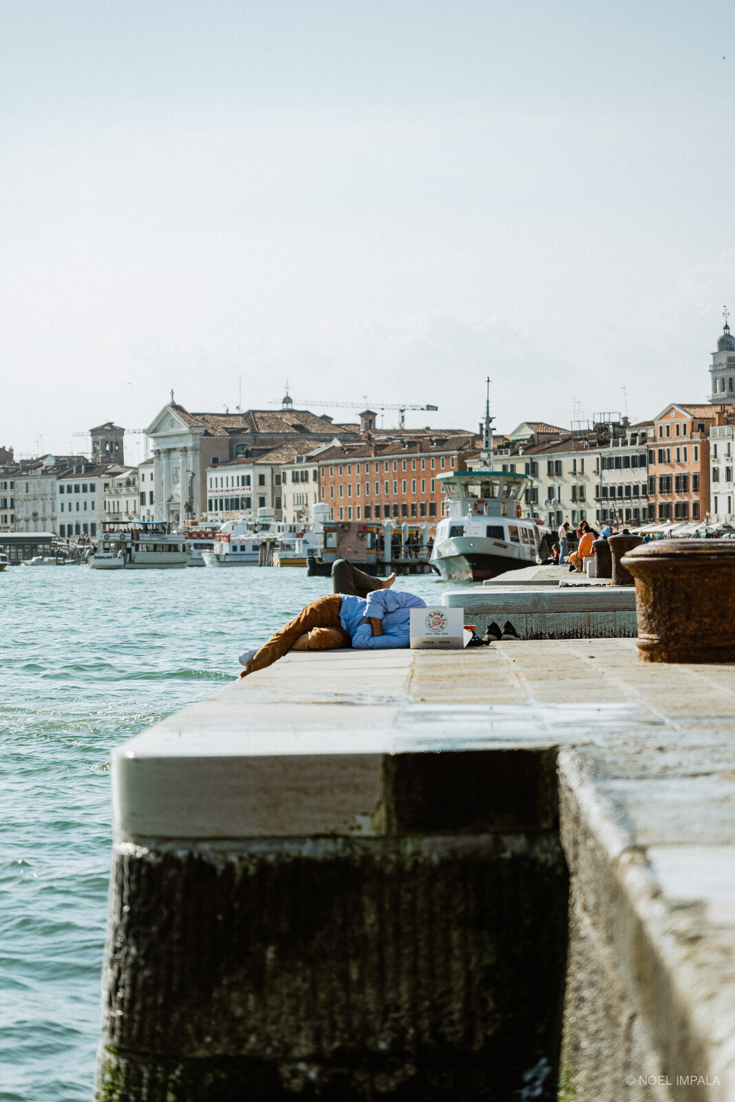 Person resting on Venice waterfront dock