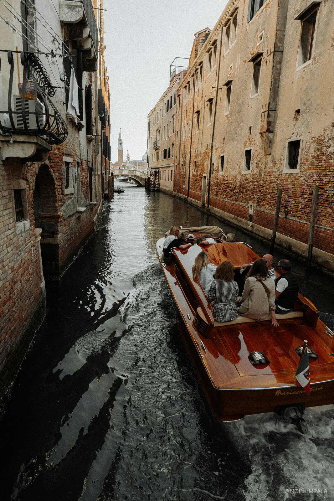 Wooden water taxi in narrow Venice canal