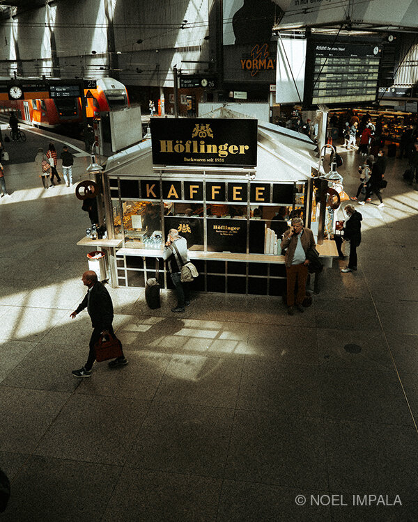 Man walking past Höflinger coffee kiosk Munich