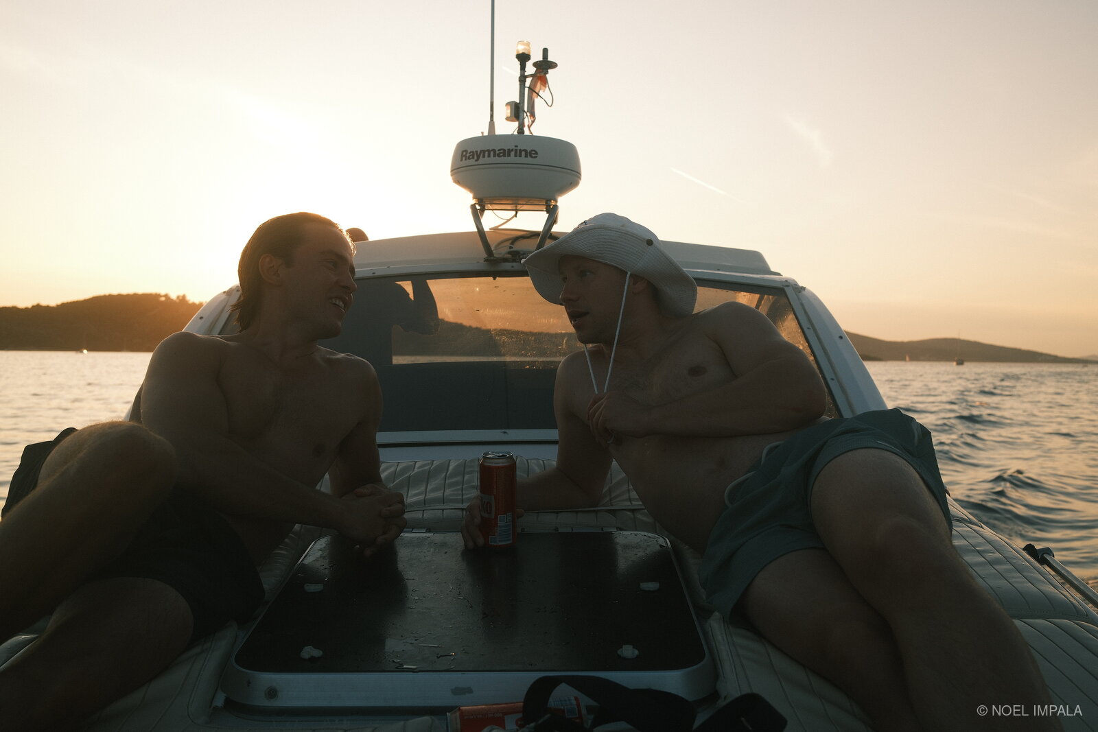 Two friends on boat at sunset